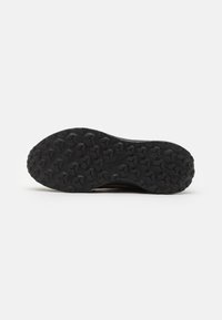 Zwarte sportieve schoenrubber met een gestructureerd patroon dat bestaat uit meerdere hexagonale noppen voor traction en grip.