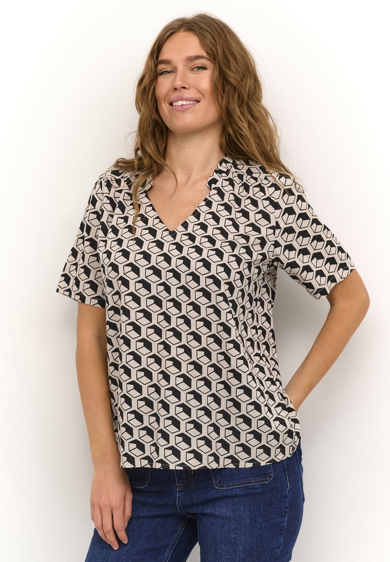 Blusa a V in un tessuto leggero con un motivo geometrico a cubo nero e crema, con maniche corte e una vestibilità rilassata.