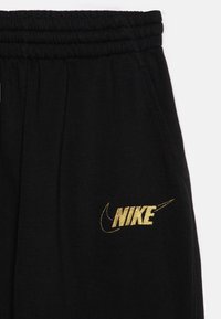Nike Sportswear CLUB LOOSE PANT - Träningsbyxor - black/gold