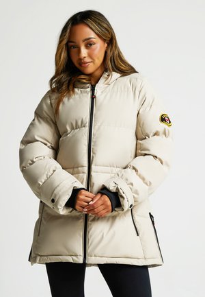 Beige Pufferjacke mit Kapuze, Reißverschluss vorne und Seitentaschen. Hat ein Logo-Emblem auf dem linken Ärmel und schwarze Akzente an den Bündchen.
