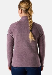 Fleece-pulloveiri teksturoidussa luumuvärissä korkealla kauluksella. Varustettu raglan-hihoilla ja logopatchilla vasemmassa olkapäässä.