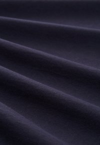 Ciemnoniebieska tkanina o widocznej teksturze i subtelnych fałdach, gładka powierzchnia i jednolity kolor w całym zakresie. Odpowiednia do różnych zastosowań tekstylnych.