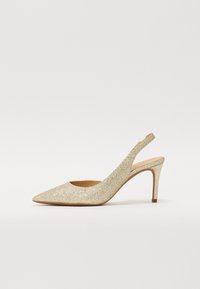 Chaussure à talon aiguille dorée pailletée avec bout pointu, présentant une découpe sur le côté et un talon effilé. Doublure intérieure lisse.