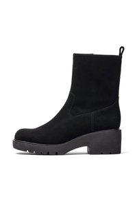 Stivale alla caviglia in suede nero con forma affusolata, suola a piattaforma nera spessa e un'apposita linguetta sul retro. Dettagli di cucitura lungo i lati.