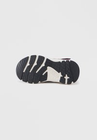 Μαύρη λάστιχη σόλα με υφή για καλύτερο κράτημα, με αντίθετη κρεμ ενδιάμεση σόλα και καθορισμένα σχέδια πέλματος για πρόσφυση.