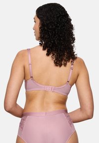 Růžová podprsenka s texturovanou tkaninou a nastavitelnými ramínky. Obsahuje zapínání na háček a oko na zadní straně a květinové vzory na odpovídajících kalhotkách.