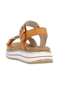 Bruna läder-sandaler med justerbara spännen, vadderad innersula, vit- och orange-randig plattformssula, öppen baksida, slät textur.