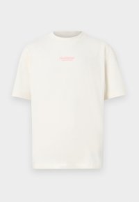 T-shirt à manches courtes de couleur crème en coton, avec un petit logo "Hollister" rose sur la poitrine dans un design simple et épuré.