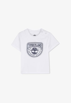 Wit T-shirt met korte mouwen van katoen, met een donkerblauw Timberland-logo en de tekst "OUTDOOR UTILITY" en het oprichtingsjaar erop gedrukt. Twee drukknoopjes op de schouder.