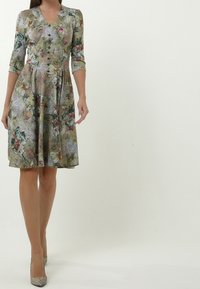 Blumendruckkleid mit V-Ausschnitt, Dreiviertelärmeln, Knopfdetails an der Vorderseite und einem ausgestellten Rock in verschiedenen Pastellfarben.