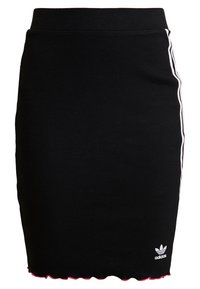 Svart ribbad stickad kjol med vita sidostramar och en scallopad rosa fåll. Litet vitt Adidas-logga på nederkanten till höger.