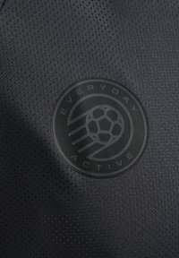 Zwarte activewear stof met een mesh-textuur. Bevat een cirkelvormig logo met "EVERYDAY ACTIVE" en een ontwerp van een voetbal in het midden.