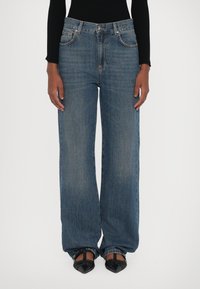 Bredde ben denimjeans i blått med midjehøyde, klassisk fem-lomme-design og en avslappet passform. Glatt tekstur med subtile falmer.