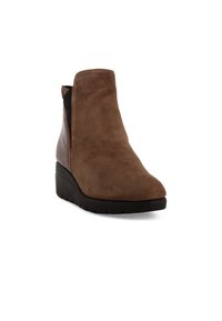 Stivale alla caviglia in suede marrone con finitura texturizzata, dotato di un pannello laterale elastico nero e una suola a cuneo imbottita per supporto.