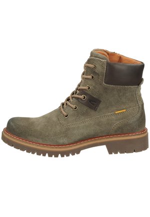 Bottines en daim vert olive avec des accents en cuir marron, bout rond, lacets beiges et semelle en caoutchouc robuste avec un motif de tread distinct.