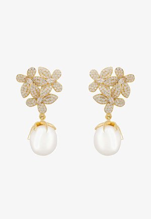 Pendientes en tono dorado con un diseño floral adornado con rhinestones. Cada pendiente tiene un gran colgante de perla blanca lisa.