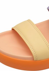 Yellow synthetic slide sandal with a wide strap. Features a smooth texture and an orange platform sole with a peach insole.