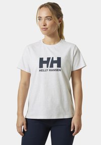 Camiseta de algodón blanca con cuello redondo, mangas cortas y un gran logotipo en azul marino de "Helly Hansen" en el frente.