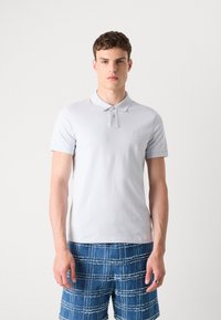 Ανοιχτό γκρι πόλο μπλουζάκι από λείο ύφασμα, με γιακά, πλάκα με δύο κουμπιά και μικρό λογότυπο στο στήθος.