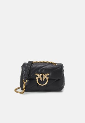 Czarna pikowana skórzana torebka na ramię z złotym łańcuszkiem oraz dwoma złotymi zapięciami w kształcie ptaków na froncie klapy.