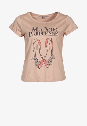 Helles rosa Baumwoll-T-Shirt mit kurzen Ärmeln, das ein Druckdesign von pinken Schuhen mit schwarzen Punkten und dem Text "Ma Vie Parisienne" zeigt.