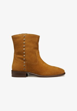 Stivaletto alla caviglia in camoscio marrone con tacco basso in legno e borchie metalliche disposte in due linee verticali lungo il lato esterno.