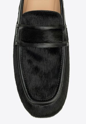 Czarna mokasyna z teksturowaną futrzaną cholewką i detalem z paskiem ze skóry, beżowe wnętrze, widok z góry.