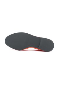 Suola di scarpa in gomma nera con accenti arancioni, caratterizzata da una superficie liscia e testurizzata e da un design della punta arrotondata.