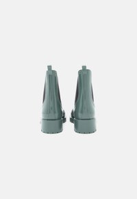 Botas de cano baixo em pele sintética verde com painéis laterais elásticos e abas de puxar; salto grosso e sola texturizada para melhor aderência; acabamento suave e brilhante.