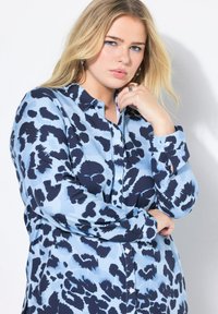 Blauwe overhem shirt met een panterprint in marineblauw. Gemaakt van lichtgewicht stof, met een klassieke kraag en lange mouwen.