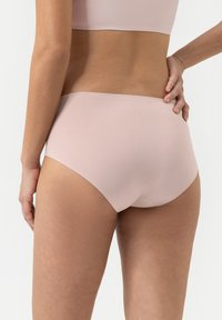 Roze naadloze slip met middelhoge snit en een gladde textuur, voorzien van een brede tailleband en geen zichtbare afdrukken.