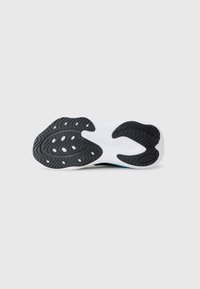 Suela de zapato con goma negra texturizada y entresuela blanca, que cuenta con un patrón de relieve ovalado y pequeños orificios de drenaje para mayor tracción.