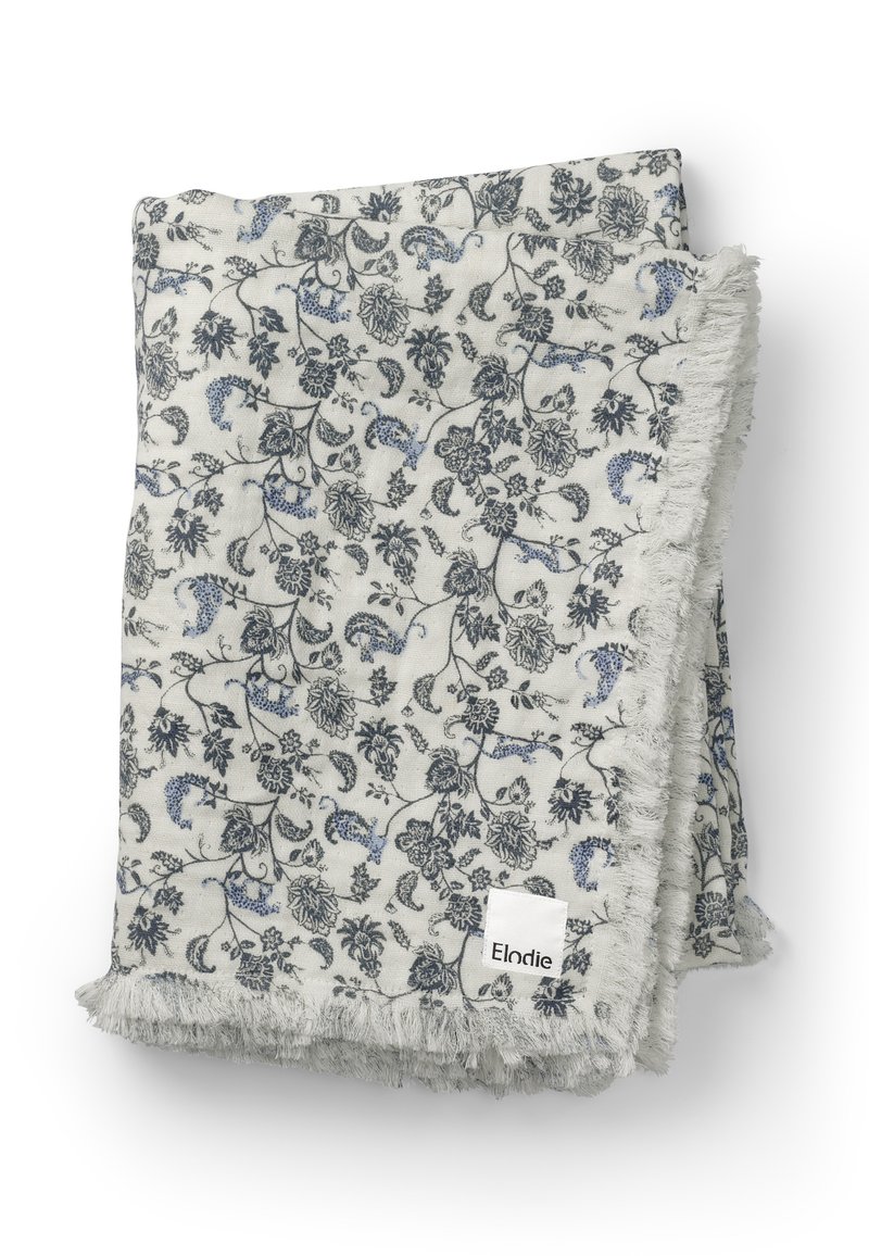 Blomsteret tæppe i lysegrå, med blå og mørkegrå mønstre. Kanterne har en blød, frandet tekstur. Mærke: Elodie.