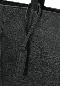 Schwarze Handtasche aus strukturiertem Leder mit glatter Oberfläche, ausgestattet mit zwei Griffen und einem Anhänger mit "TOM TAILOR", der in die Ecke geprägt ist.