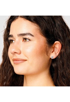 Silberne Steckerohrringe mit einem blauen Edelstein in einem runden Design. Verfügen über eine glänzende Oberfläche und eine glatte Textur.