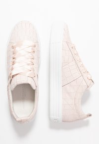 Jasnoróżowe sneakersy o teksturowanej powierzchni z białymi grubymi podeszwami, z satynowymi sznurowadłami, zaprezentowane z widoków z góry i z boku na białym tle.