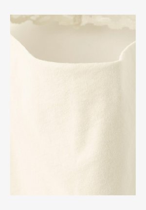 Close-up of a cream-colored, knit fabric with a curved edge and fine ribbed texture.