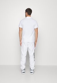 Lacoste Sport TENNIS PANT - Pantalones deportivos - noir/blanc