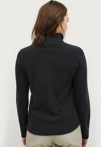 Zwarte fleece pullover met een hoge kraag, lange mouwen en een gestructureerd oppervlak. Rechte zoom op de taille, minimale stikseldetails.