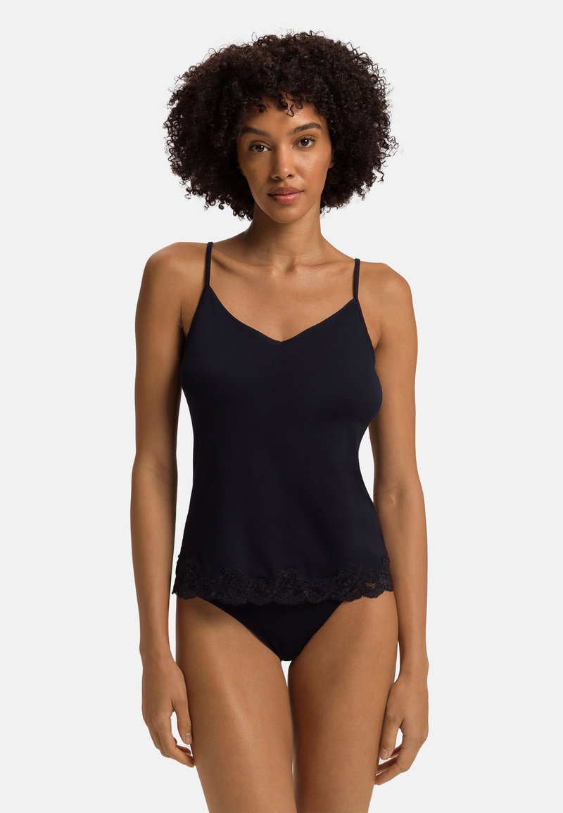 Černá tílko s tenkými ramínky a výstřihem do V, s texturovaným krajkovým lemem ve spodní části. Měkká tkanina s přiléhavým střihem.