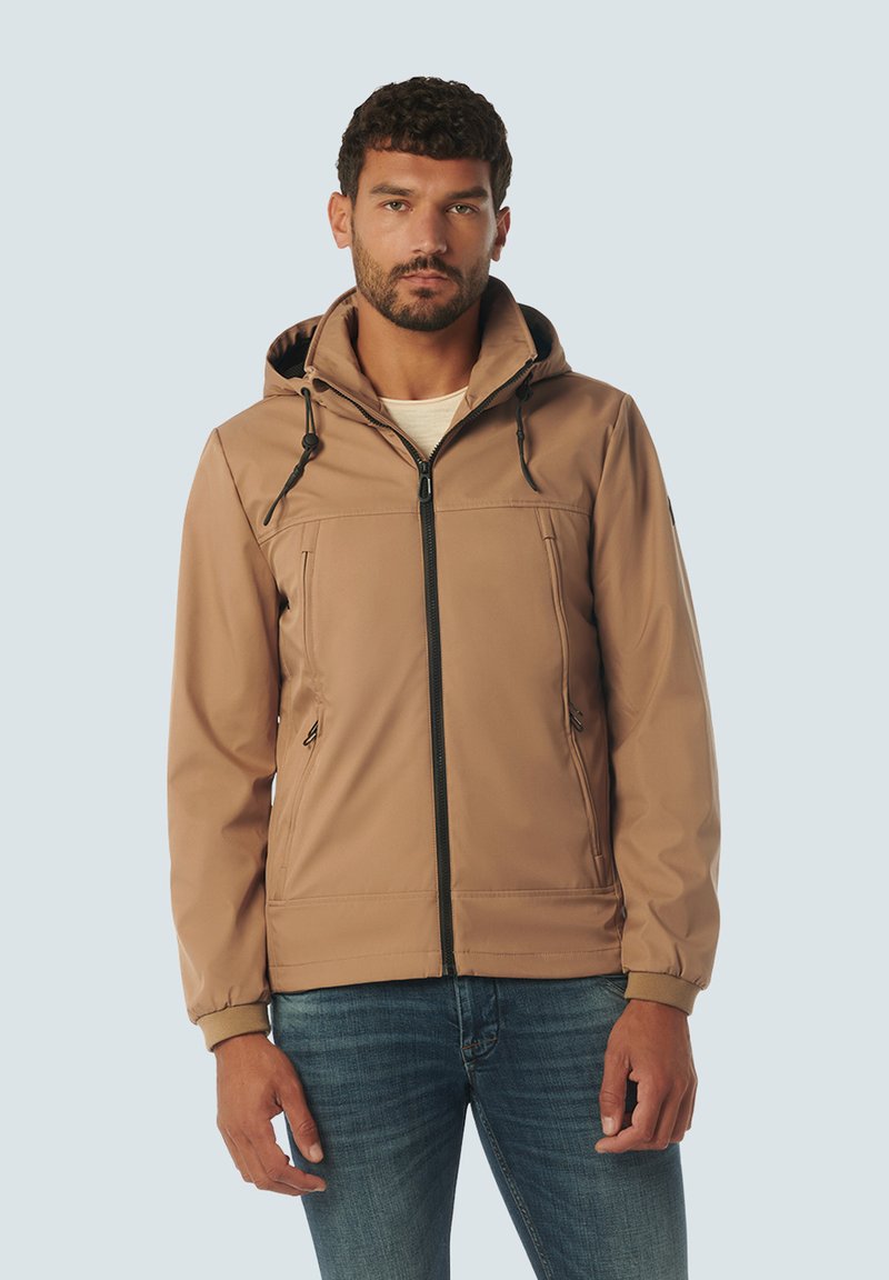 Bruine soft-shell jas met capuchon, voorzien van een rits aan de voorkant, trekkoorden en twee voorzakken, tegen een lichtblauwe achtergrond.