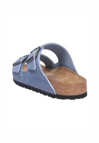 Sandal con cinturini blu scamosciato, con soletta in sughero, due fibbie regolabili e suola in gomma testurizzata nera. Design aperto sul retro per una facile calzata.