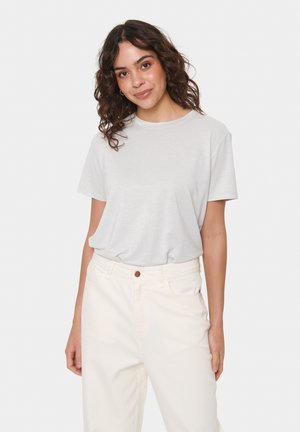 Helles graues T-Shirt mit kurzen Ärmeln, lockerer Passform, runder Ausschnitt und weicher Textur, kombiniert mit hochgeschnittenen cremefarbenen Hose.