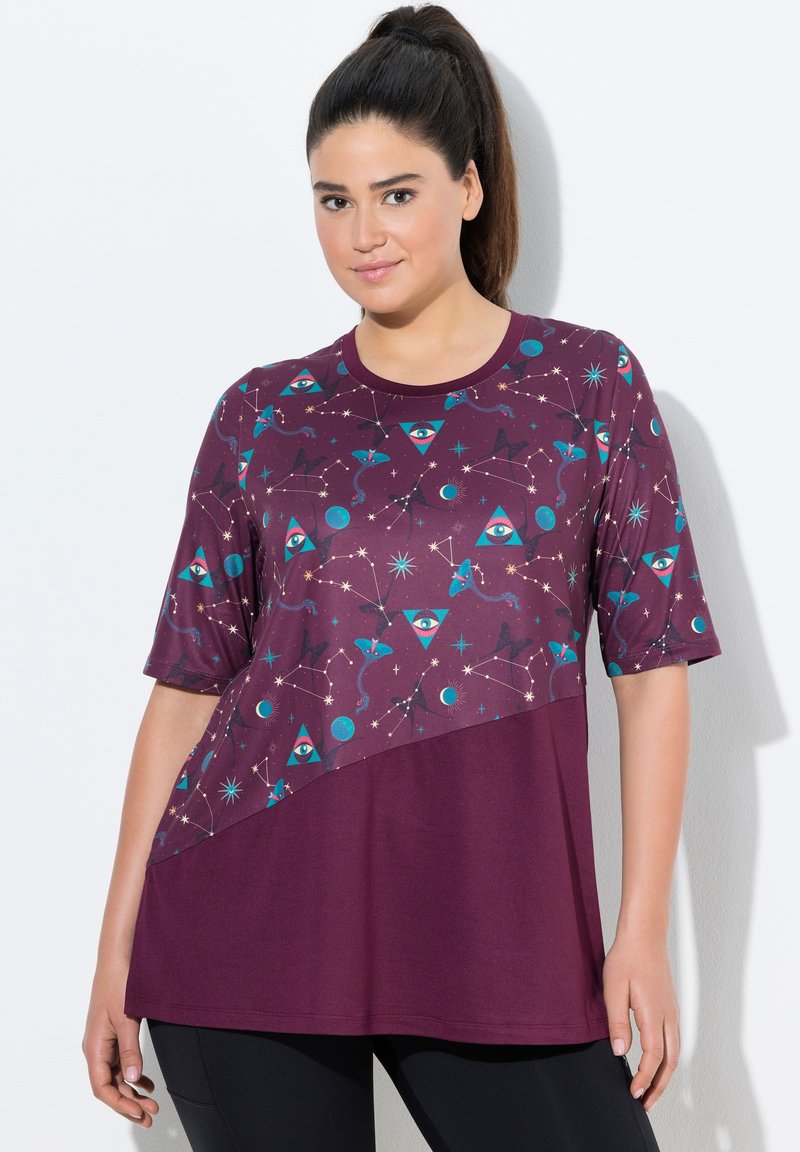 Chemise violette à manches courtes avec un motif géométrique comprenant des yeux, des étoiles et des planètes. Tissu doux avec une coupe décontractée et un col rond.