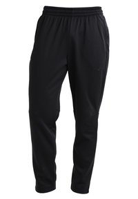 Black athletic pants made of soft fabric with an elastic waistband, tapered legs, and side pockets. Features a subtle logo detail.