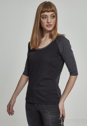 Maglietta a maniche tre quarti nera e grigia, con scollo rotondo, in tessuto morbido, design aderente, con un sottile contrasto di colore sulle maniche, stile informale.
