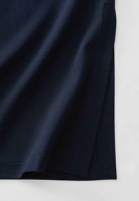 Navyblaue T-Shirt mit glatter Textur, seitlichen Schlitzen am Saum und dezenten Stichdetails. Schlichtes und minimalistisches Design.