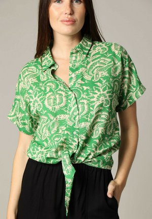Groene short-sleeve shirt met een wit bloemenpatroon, knoopsluiting aan de voorkant en een geknoopt ontwerp bij de taille. Lichtgewicht stof, ontspannen pasvorm.