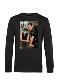 Černá mikina s potiskem dvou mužů opírajících se o dřevěný stůl, jeden sedí a druhý stojí, s textem "The Sopranos" nad nimi.
