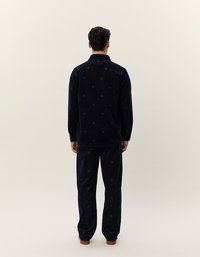 Set di camicia e pantaloni in corduroy blu navy, con motivi circolari. La camicia ha un colletto e bottoni; i pantaloni hanno una vestibilità comoda.